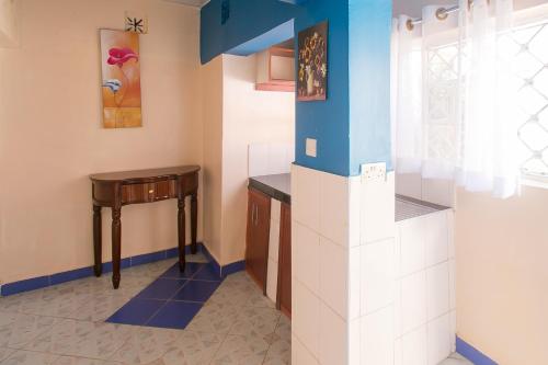 a kitchen with blue and white walls and a table at Zarita Boutique Hotel in Nairobi