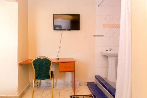 a room with a desk and a television on the wall at Zarita Boutique Hotel in Nairobi