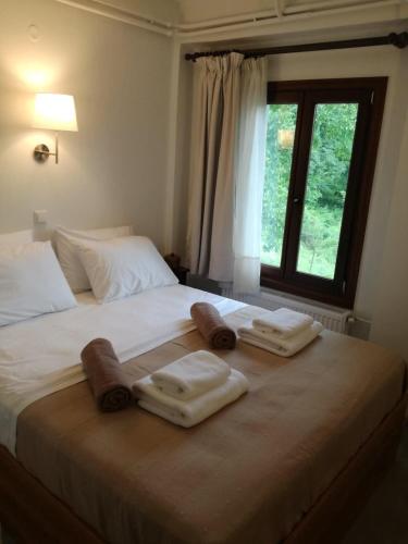 łóżko z 3 ręcznikami i oknem w obiekcie House in the forest w mieście Tsagarada