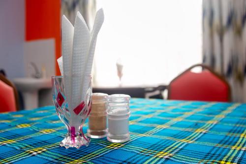 a table with a glass vase and two candles on it at Zarita Boutique Hotel in Nairobi
