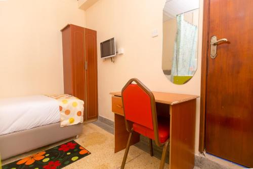 a bedroom with a desk and a bed and a desk and a chair at Zarita Boutique Hotel in Nairobi