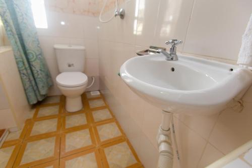 a bathroom with a white sink and a toilet at Zarita Boutique Hotel in Nairobi