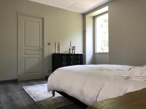 a bedroom with a white bed and a window at Les Chambres d'Hotes chez Alisa et Daniel in Sarlat-la-Canéda
