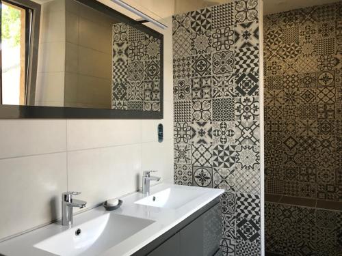 a bathroom with two sinks and a mirror at Les Chambres d'Hotes chez Alisa et Daniel in Sarlat-la-Canéda