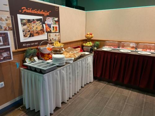 a buffet line with food on top at Hotel New Fair Munich Messe in Munich