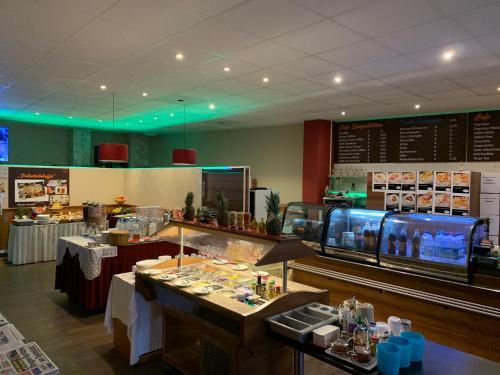 a restaurant with tables and a counter with a buffet at Hotel New Fair Munich Messe in Munich