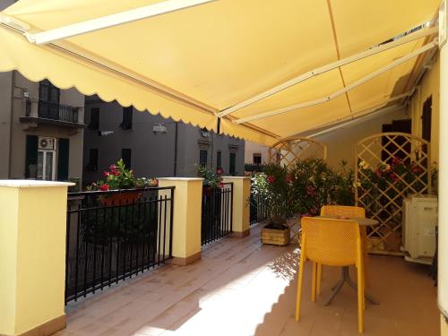 patio z żółtym parasolem, stołem i krzesłami w obiekcie Affittacamere Rosy w mieście La Spezia