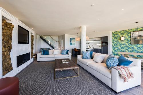 a living room with two white couches and a table at Carbis Bay and Spa Hotel in St Ives