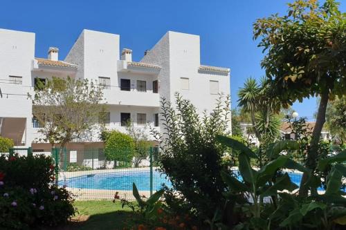een uitzicht op een gebouw met een zwembad bij Los Geranios - Beach Apartment in La Cala de Mijas