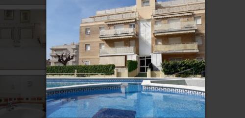 ein Gebäude und ein Pool vor einem Gebäude in der Unterkunft Apartamento Cunit Playa in Cunit