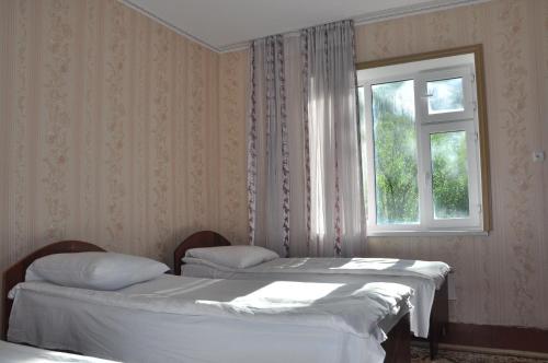 - 2 lits dans une chambre avec fenêtre dans l'établissement Guest House Sary-Chelek, à Arkit