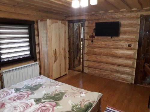 a bedroom with a bed and a flat screen tv at Маєток горгани in Synevyrsʼka Polyana