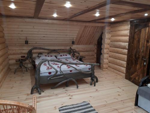 a bedroom with a bed in a log cabin at Маєток горгани in Synevyrsʼka Polyana