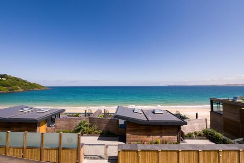 a row of houses on a beach near a body of water at Carbis Bay and Spa Hotel in St Ives