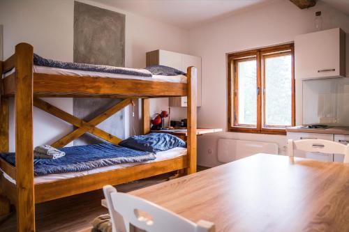 a room with two bunk beds and a table at Apartments Arh in Bohinjska Bistrica