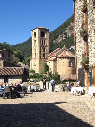 an old building with a clock tower in a town at Casa Rural Mollo, Vall de Camprodon in Molló