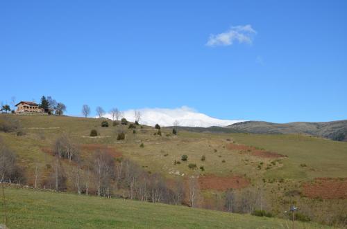 a house on top of a hill in a field at Casa Rural Mollo, Vall de Camprodon in Molló