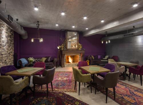 a restaurant with tables and chairs and a fireplace at Hover Boutique Hotel in Dilijan