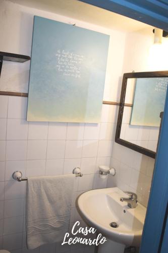 a bathroom with a sink and a chalkboard on the wall at Casa Leonardo in Favignana