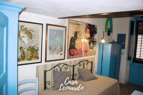 una camera con un letto e alcune immagini sul muro di Casa Leonardo a Favignana