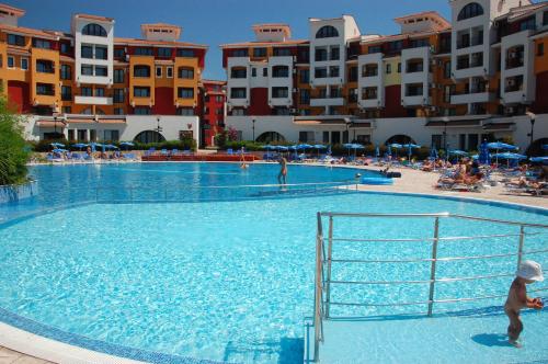 a large swimming pool with people in a resort at Visit Sunny Beach Marina Apartments in Ravda