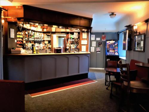 a bar in a restaurant with a counter at The Imperial Hotel in Castle Douglas