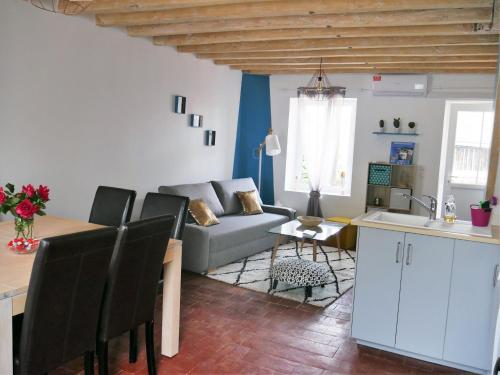 cocina y sala de estar con sofá y mesa en Casa Maya en Saint-Aignan