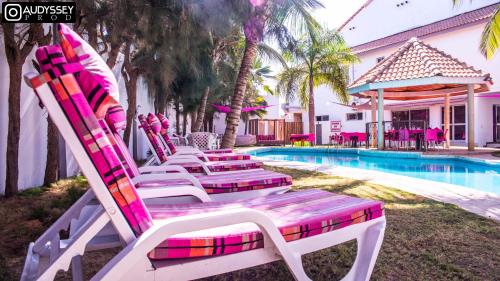 a row of lounge chairs next to a swimming pool at La maison de celine in Dakar