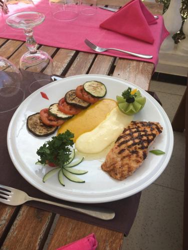 a plate of food with meat and vegetables on a table at La maison de celine in Dakar