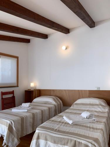 two beds sitting next to each other in a room at Arco 37 in Alghero