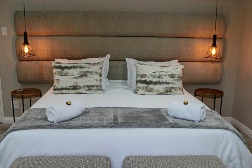 a bed with two white towels on top of it at Stonehill Villa in Bloemfontein