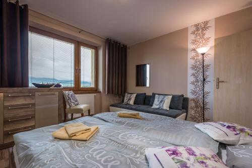 ein Hotelzimmer mit 2 Betten und einem Sofa in der Unterkunft Apartment Provensal in Liptovský Mikuláš
