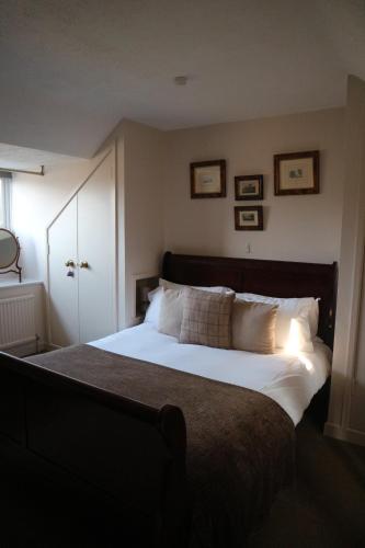 a bedroom with a large bed with white sheets and pillows at The George at Nunney in Frome