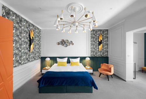 Un dormitorio con una cama azul y una lámpara de araña. en Hotel Del Corso en Timisoara