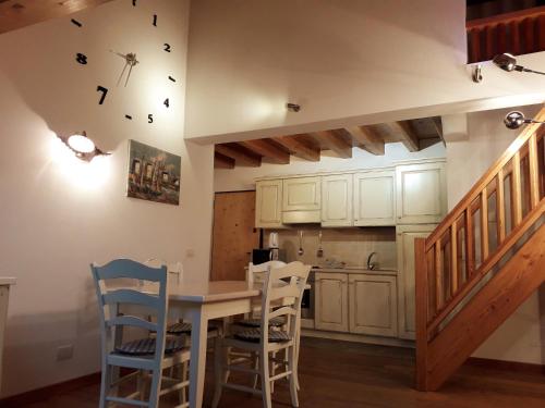 a kitchen with a table and chairs and a staircase at Casa Dai Fre' CIPAT ZERO22018-AT-ZERO53006 in Bocenago