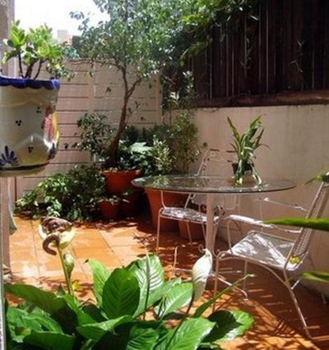 a patio with a table and a bunch of plants at Posada Colonial Beach Villas in San Juan
