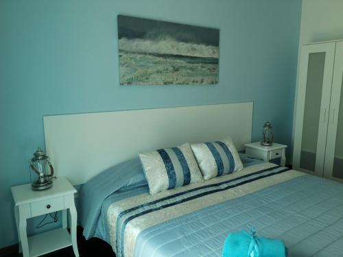 a bedroom with a bed with two tables and a painting at Nature Guesthouse in Lagos