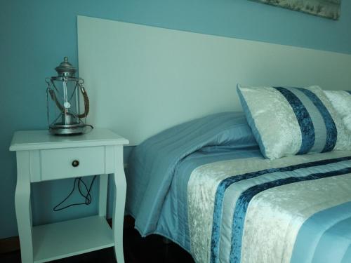 a bedroom with a bed and a nightstand with a lamp at Nature Guesthouse in Lagos
