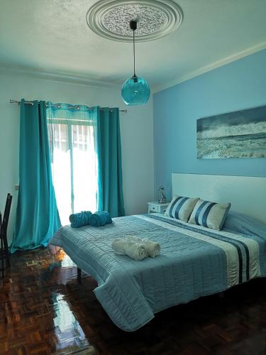 a blue bedroom with a large bed with blue curtains at Nature Guesthouse in Lagos