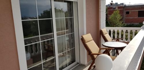 a balcony with two chairs and a table and a window at Villa Anastasia Ksamil in Ksamil