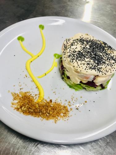 a white plate topped with a sandwich with sprinkles at Hotel Jole in San Mauro a Mare