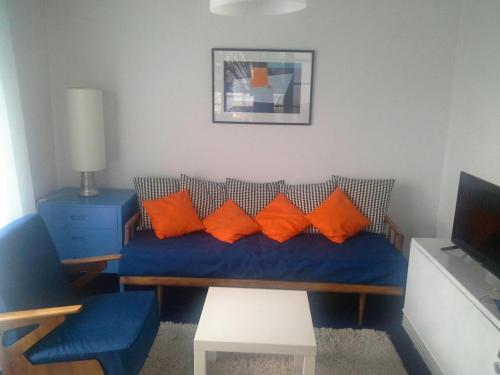 a living room with a blue couch with orange pillows at Casablanca in Herceg-Novi