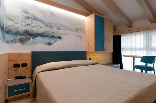 um quarto com uma cama e um quadro na parede em Hotel Majorka em Andalo