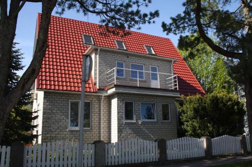 a house with a red roof and a white fence at Kotka Housing in Pärnu