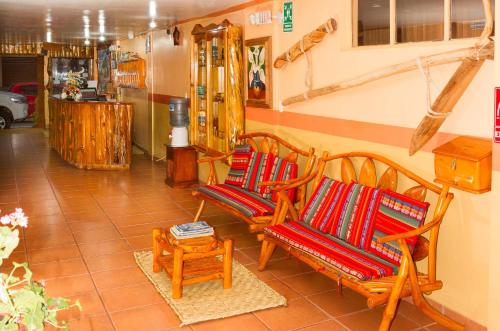 a room with three rocking chairs and a table at Hotel Santafe Inn in Otavalo