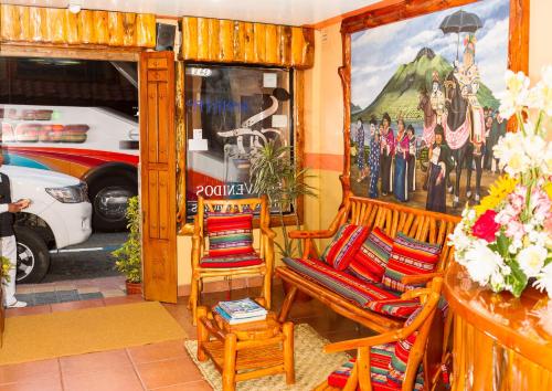 a room with two chairs and a painting of a bus at Hotel Santafe Inn in Otavalo
