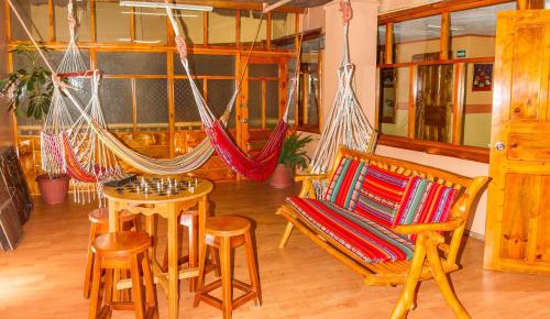 a room with a hammock and a table and chairs at Hotel Santafe Inn in Otavalo