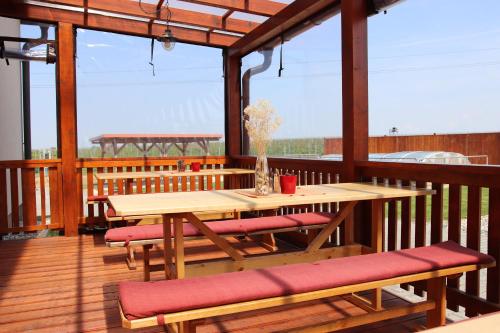 a wooden deck with a wooden table and benches at Penzion Kosík Tvrdonice in Tvrdonice