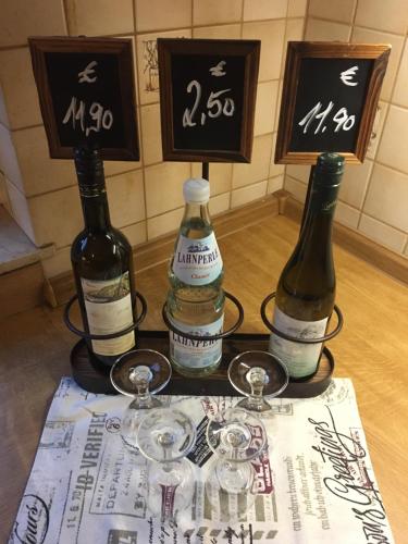 three bottles of wine sitting on a table with glasses at Das Loreley Weinstuebchen in Sankt Goarshausen