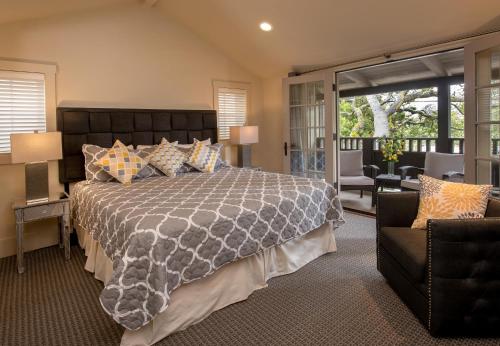 a bedroom with a large bed and a balcony at Carmel Country Inn in Carmel